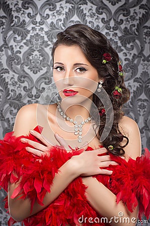 A young brunette woman holding red feathers