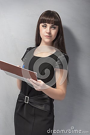 Young Brunette Woman With Spring Notebook against Grey Wall
