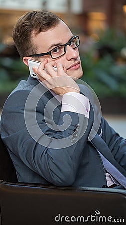 Young business man working with mobile phone. Vertical portrait.