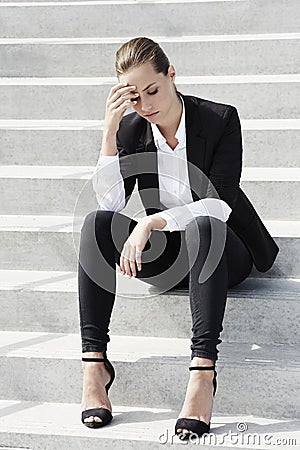 Young business woman sitting outside on stairs