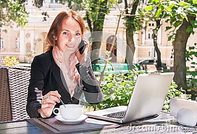 Young business woman is using smart phone and notebook in summer