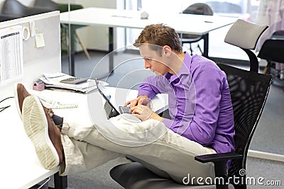 Young businessman in his office working with tablet - bad sitting posture