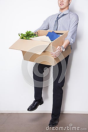 Young Businessman holding box of office items