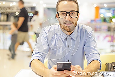 Young Businessman seating on table in restoran and use mobile de