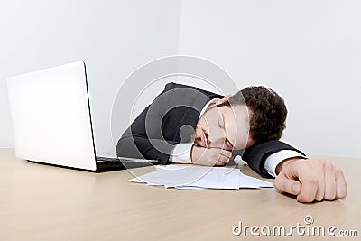 Young businessman sleeping on the office desk