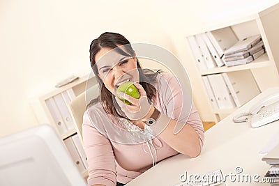 Young businesswoman bite apple at office