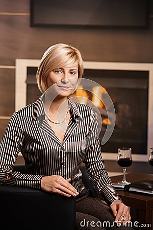 Young businesswoman sitting in front of fireplace