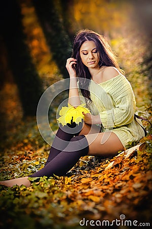 Young Caucasian sensual woman in a romantic autumn scenery. Fall lady .Fashion portrait of a beautiful young woman in forest