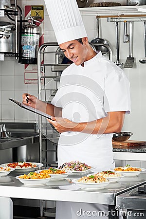 Young Chef With Clipboard At Kitchen