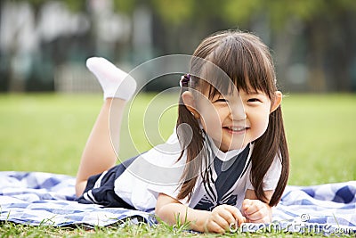 Young Chinese Girl Lying On Blanket In Park