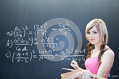 Young college student writing on the chalkboard