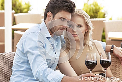 Young couple having red wine at outdoor restaurant