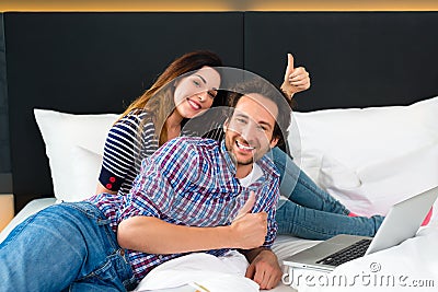 Young couple in Hotel in bed with wifi and computer