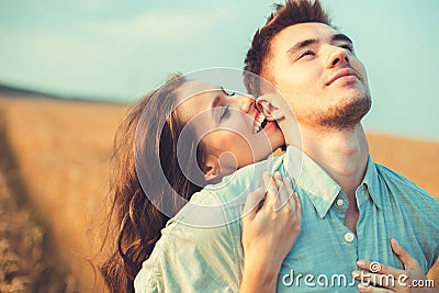 Young couple in love outdoor.Couple hugging.Young beautiful couple in love staying and kissing on the field on sunset.
