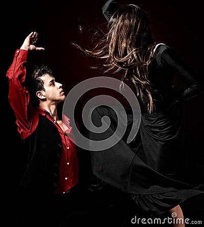 Young couple passion flamenco dancing on red ligh