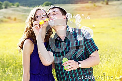 Young couple play together with bubble blower