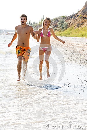 Young couple running along the beach