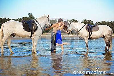 Young couple in the sea with horses