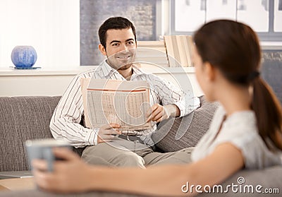 Young couple sitting in living room on sofa