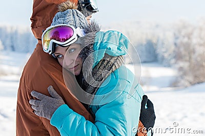 Young couple ski goggles embrace winter snow