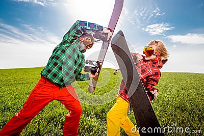 Young couple in ski suit have fun battle with snowboards togethe