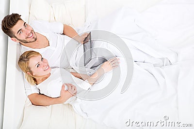 Young couple with a Tablet PC in Bed