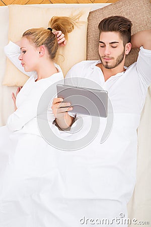 Young couple with a tablet PC in bed