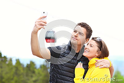 Young couple taking pictures in mountains