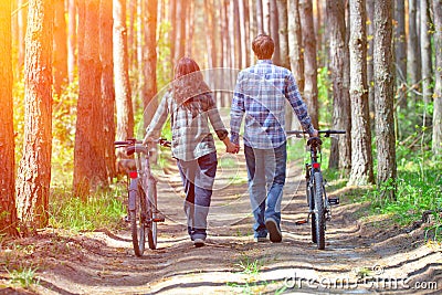 Young couple walk with bicycles
