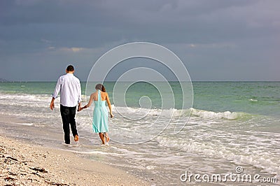 Young couple walking along bonita beach as sunsets
