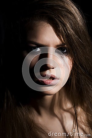 Young crying woman on dark background