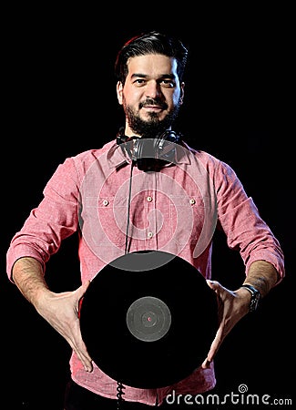 Young DJ in white costume holding vinyl record in