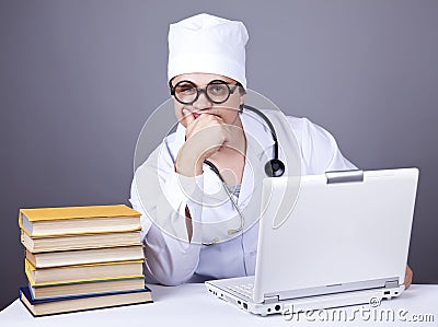 Young doctor with books and computer.