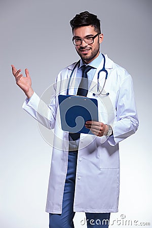 Young doctor presenting with clipboard in hand