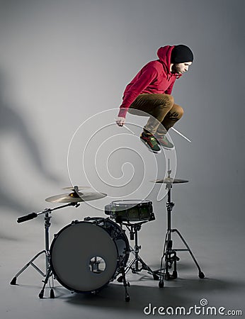Young drummer jumping while playing
