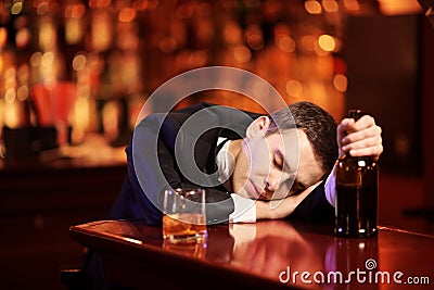 Young drunk man sleeping in the bar
