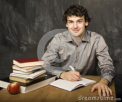 The young emotional student with the books and red apple in class room