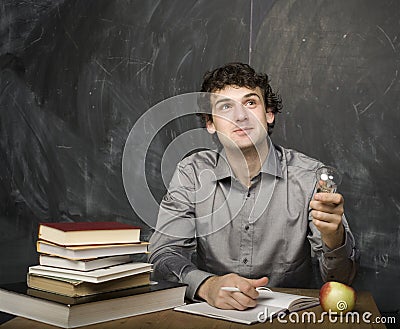 The young emotional student with the books and red apple in class room