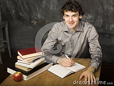 The young emotional student with the books and red apple in class room