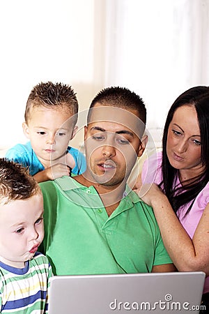 YOUNG FAMILY USING LAPTOP