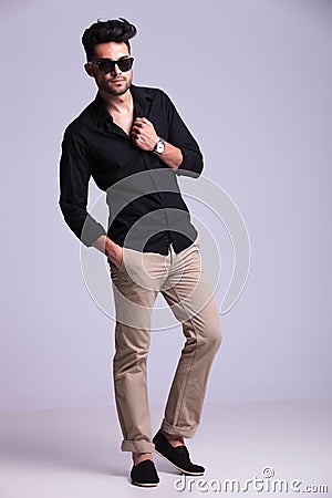 Young fashion man posing with hand on shirt