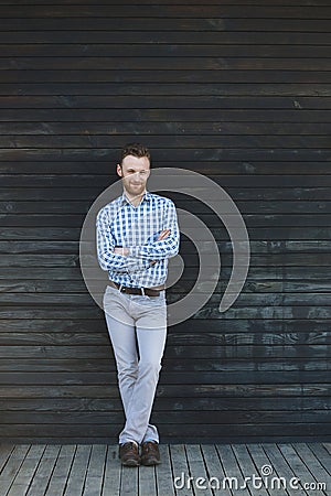 Young fashionable man against wooden wall