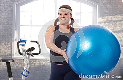 Young fat woman exercising with fit ball