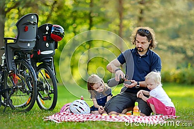 Young father and his daughters having a picnic