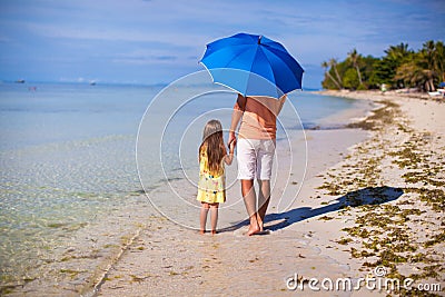 Young father and his little daughter walking under