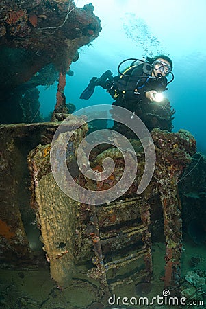 Young female SCUBA Diver explores shipwreck