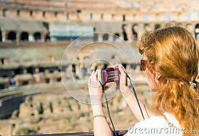 Young female tourist takes a picture inside the Coliseum in Rome