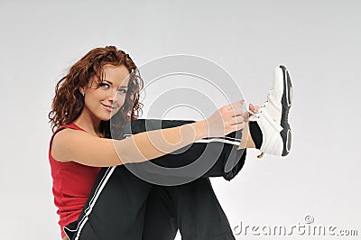 Young fitness woman ties lace on her shoe