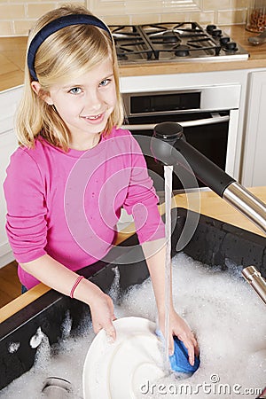 Young Girl Cleaning Dishes Looking at Camera