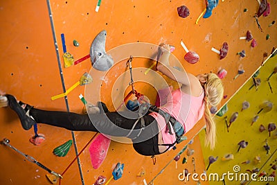 The young girl climbs the steep wall